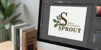 Computer screen shows logo design for Sprout Media Management with books on branding nearby.