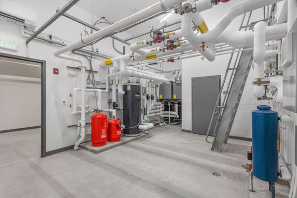 Industrial mechanical room with pipes, tanks, and valves in a clean, organized space.