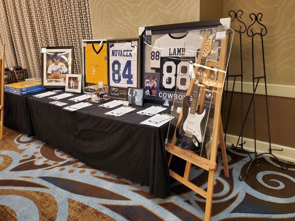 Sports memorabilia and a guitar displayed on a table for auction or exhibition.