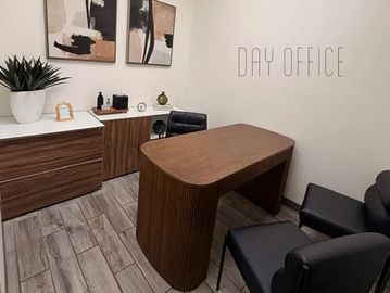 Modern office space with wooden furniture and black chairs.