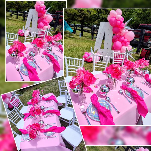 Elegant pink-themed outdoor birthday table setting with flowers and balloons.