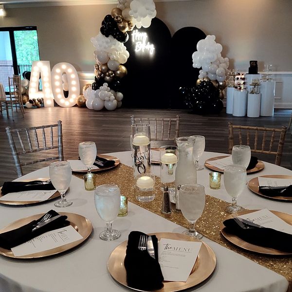 Elegant 40th birthday party setup with gold and black decorations.