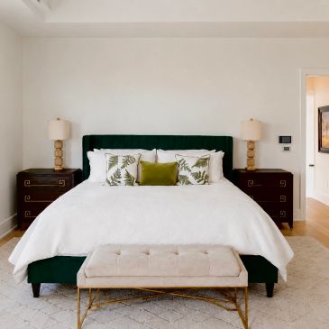 Modern bedroom with green accents and elegant furniture.
