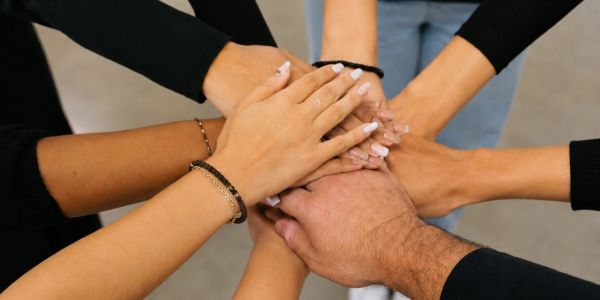 Hands stacked together showing unity.