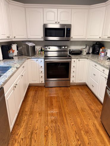Modern kitchen with white cabinets and stainless steel appliances.