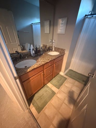 Modern bathroom with double sinks and shower.