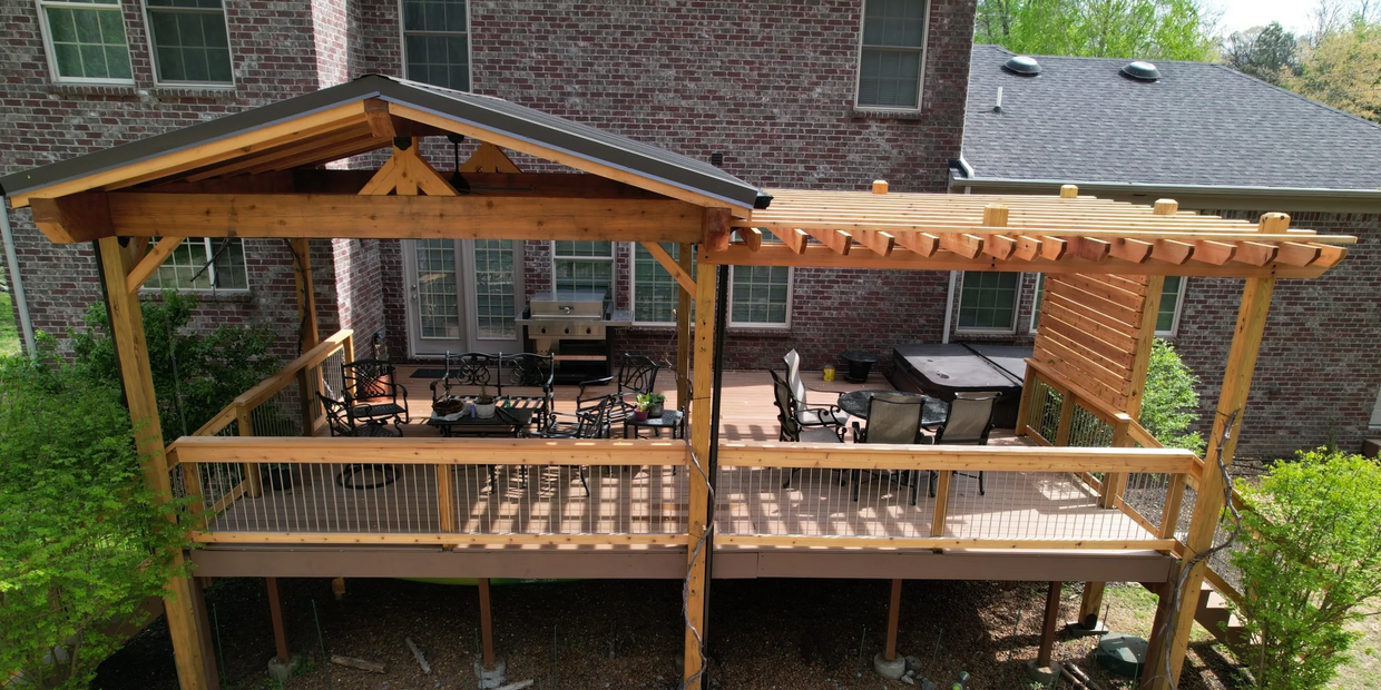 Wooden deck with handrailing and patio cover with a metal corrugated roof.