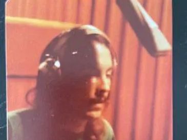 Man with long hair and a mustache in a recording studio