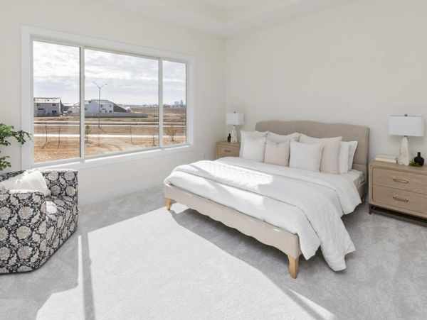 Bright modern bedroom with large window and cozy bed.