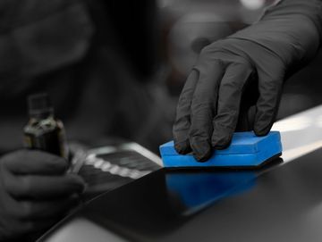 A ceramic coating being hand-applied to a vehicle's exterior paint and trim.