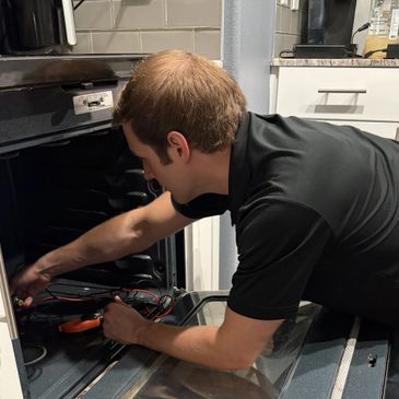 Appliance technician repairing oven