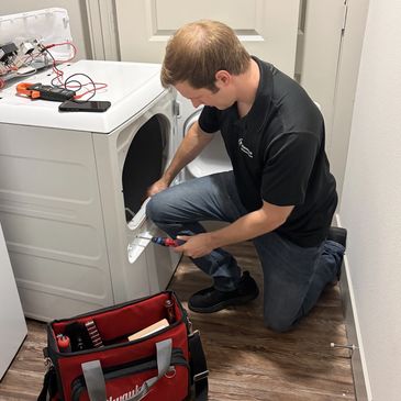 Appliance technician repairing dryer