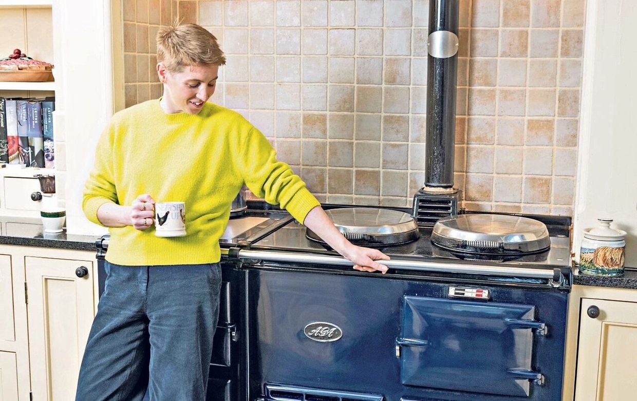 a man standing next to an AGA gas cooker