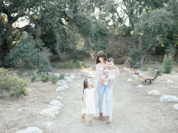 Mother walking with her two daughters outdoors.