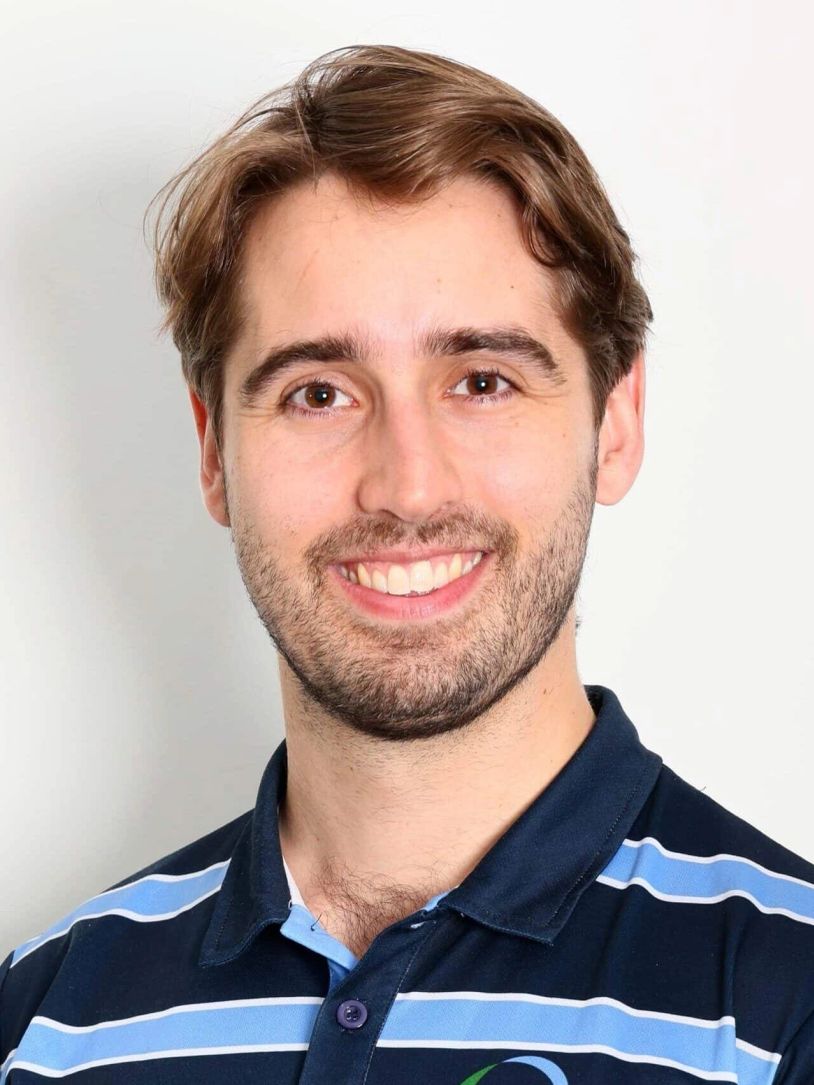 Smiling young man with brown hair in a striped polo shirt.