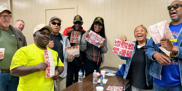 Happy group showing tickets and smiling indoors.