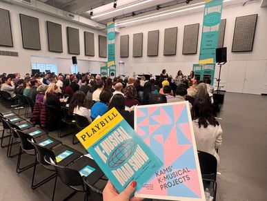 Audience attending a K-Musical Road Show event in a large room.