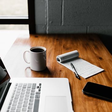 Laptop and coffee on a desk.