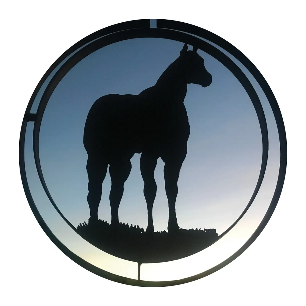Silhouette of a horse within a circular frame against a twilight sky.