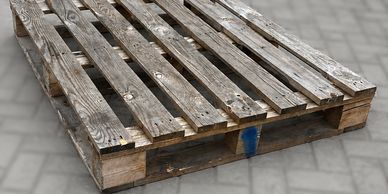 Worn wooden pallet on pavement.