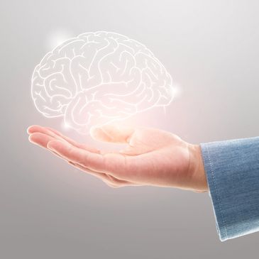 Hand holding a glowing outline of a brain suggesting supporting mental health.