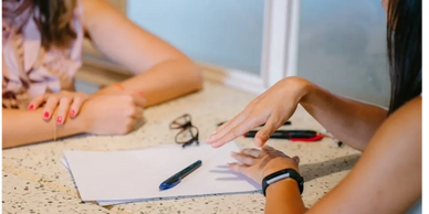 Hands of two people doing Drawing and Talking therapy with pencil and paper.