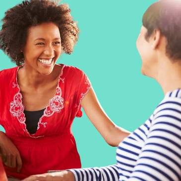 Two adults smiling happily and looking relaxed and enjoying group drawing and talking session.