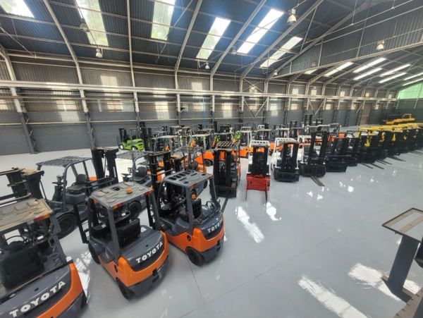 Warehouse filled with several lined-up forklifts. 1mm Epoxy 