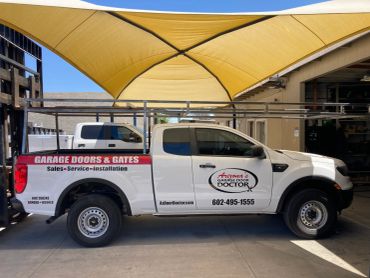 White pickup truck advertising garage doors and gates service.