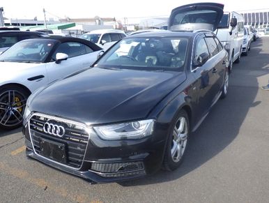 Black Audi sedan parked in a lot with other cars.
