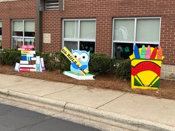 Yard signs can celebrate any occasion. Crayons, an owl holding a ruler and a stack of books. 