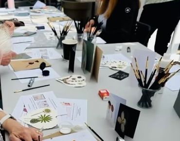 A creative workspace with art supplies and botanical illustrations.