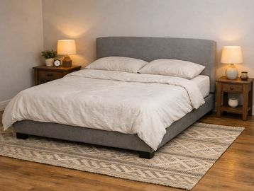 Cozy bedroom with a gray upholstered bed and matching nightstands.