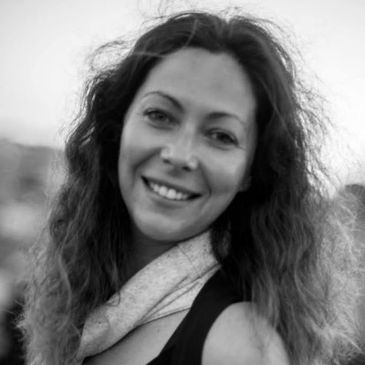 Smiling woman with wavy hair in a black and white photo.