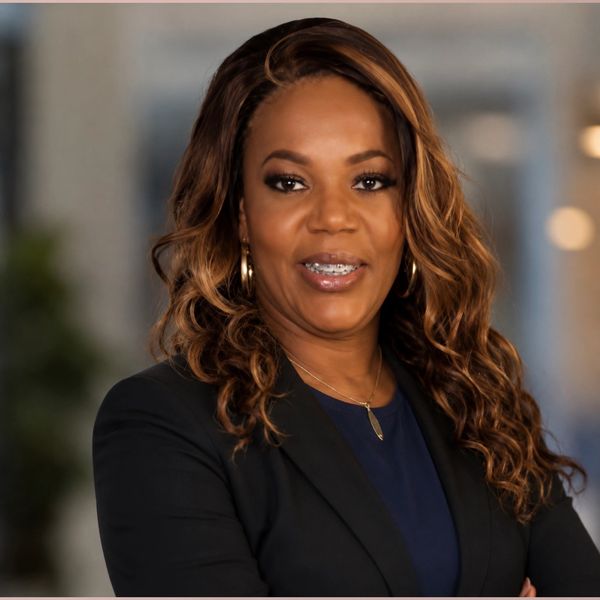 Confident woman smiling, wearing a black blazer.