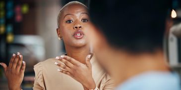A young woman having a conversation with a man.