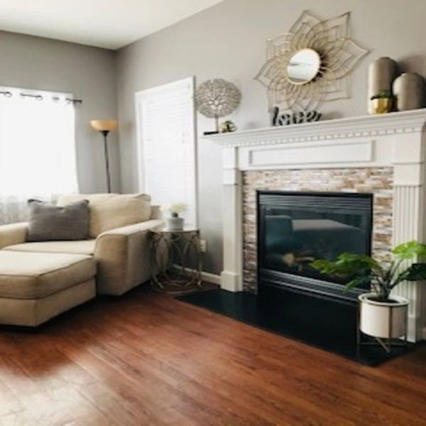 Fireplace next to chair with ottoman.