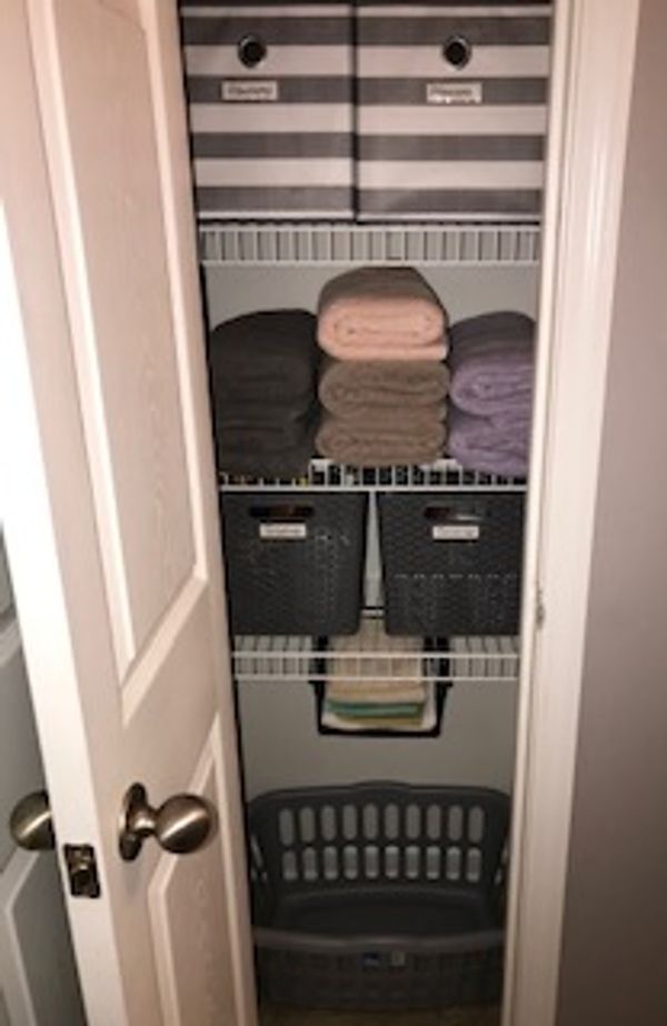 Organized linen closet with neatly folded towels.