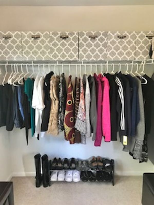 Organized clothes and shoes in master closet.