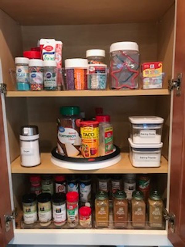 Organized spice and baking cabinet in kitchen.