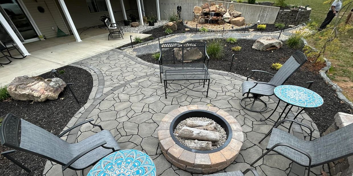 Paver Patio and landscaping with a firepit in the back yard of a residential house.