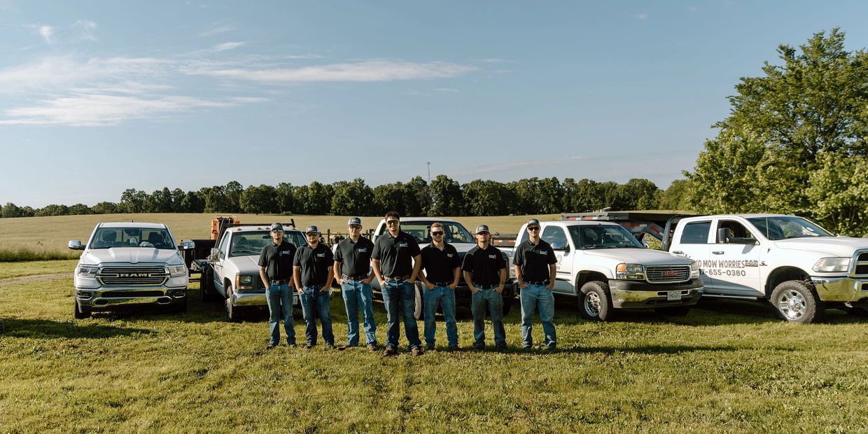 Crew of Now Mow Worries Lawn care and Landscape, LLC posing in front of equipment. 