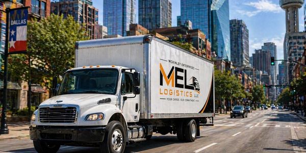 A McKinley Enterprises MEL Logistics truck driving through a sunny Dallas street.