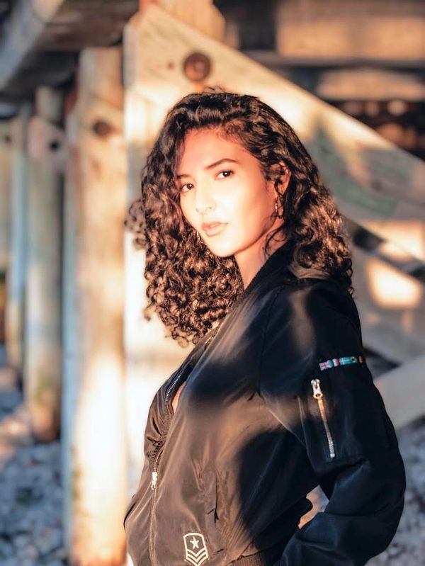  golden light photoshoot, curly hair female model, under pier