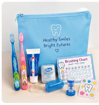 Kids' dental hygiene kit with toothbrushes, toothpaste, floss, and a brushing chart.