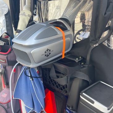 A portable heater mounted inside a vehicle with various equipment around.
