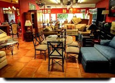Cozy furniture store with various chairs, sofas, and tables in warm lighting.