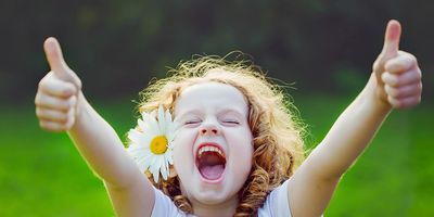 young girl holding two thumbs up