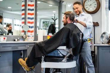 Matt cutting a client's hair while standing to the side of the chair