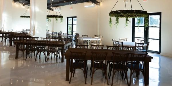 Spacious, modern dining area with wooden tables and hanging plant decorations.